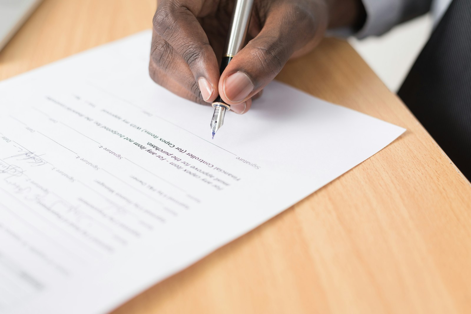 Two people reviewing and signing a contract at a table